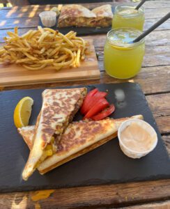 Täytettyjä tortilla-lettuja, ranskalaisia ja limonadia pöydällä.